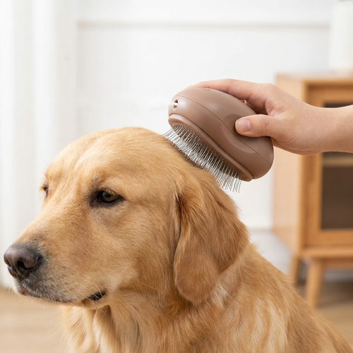 A brown electric grooming brush being used on a golden retriever