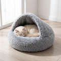 Cat curled inside a grey faux fur hooded donut cat bed